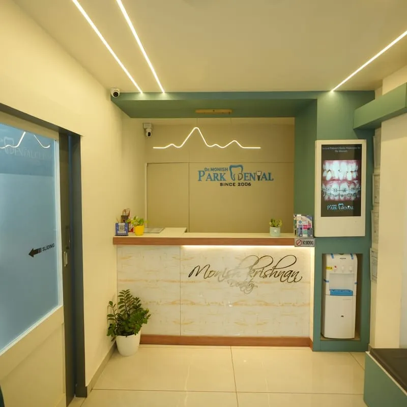 Modern Park Dental Clinic building exterior with glass facade and tropical greenery in Kochi